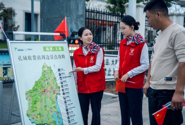 1759889938923177.png 合安中心孔城站文旅推介員向前來咨詢司乘人員贈送小國旗.png